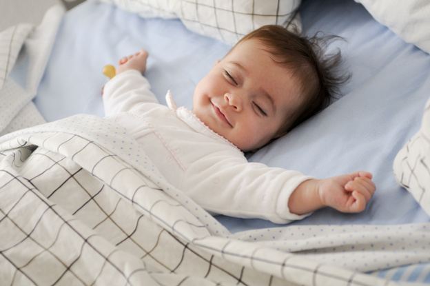 Smiling sleeping baby that is possible dreaming